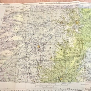 May include: A vintage World Aeronautical Chart, showing a detailed map of the central United States. The map is printed on a cream-colored paper with black lines and text. The map is divided into sections with different colors, including green, yellow, and brown. The map includes a scale bar and a compass rose.
