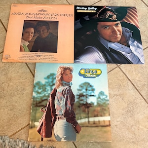 May include: Three vintage vinyl record albums. The album covers feature Merle Haggard & Bonnie Owens, Mickey Gilley, and Tanya Tucker. The Merle Haggard album is titled "That Makes Two of Us." The Mickey Gilley album is titled "You Don't Know Me." The Tanya Tucker album is titled "Tanya Tucker."
