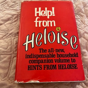 May include: A vintage red book titled "Help! from Heloise." The cover features white and black text with a yellow flower graphic. The book is a household companion volume to "Hints from Heloise."