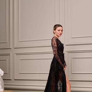 Sheer black lace dressing gown with intricate patterns, scalloped edges, and a long, trailing hem. Perfect for boudoir or bridal photography.
