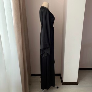 Puede incluir: Una bata larga negra con mangas anchas y cintur&oacute;n a juego. La bata est&aacute; hecha de una tela suave y fluida y se exhibe en un maniqu&iacute;. Las mangas tienen un dise&ntilde;o en capas &uacute;nico. La bata es larga hasta el suelo.