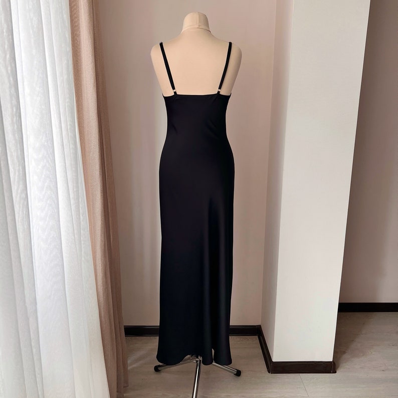 K&ouml;nnte beinhalten: Ein schwarzes, bodenlanges, &auml;rmelloses Schlupfkleid mit geradem Ausschnitt.