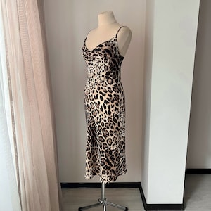 May include: A brown and black leopard print slip dress with a cowl neck and thin straps.