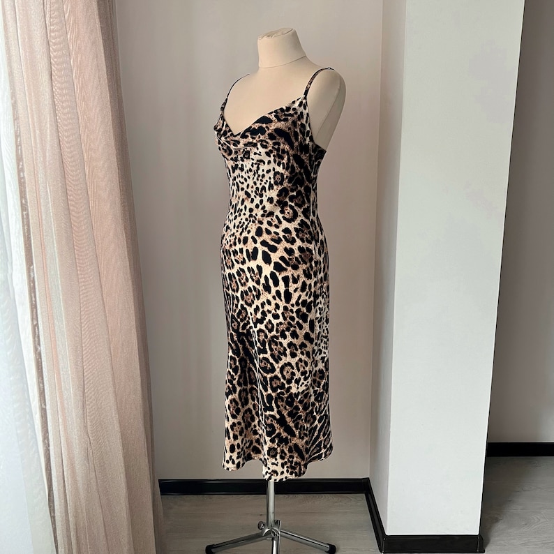 May include: A brown and black leopard print slip dress with a cowl neck and thin straps.