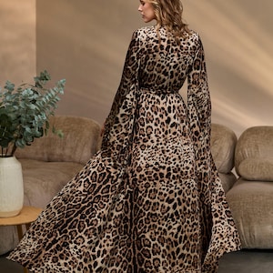 Puede incluir: Un vestido maxi de manga larga, de estampado de leopardo marr&oacute;n y negro, con cuello en V y cintura con lazo.