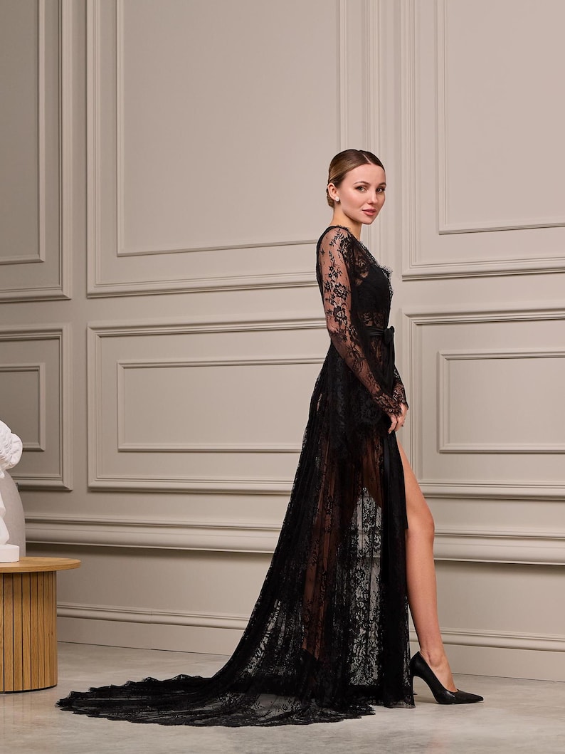 Sheer black lace dressing gown with intricate patterns, scalloped edges, and a long, trailing hem. Perfect for boudoir or bridal photography.