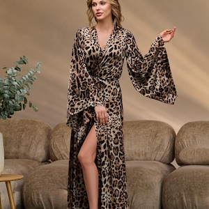 Puede incluir: Una bata larga de estampado de leopardo marr&oacute;n y negro con cuello en V, mangas largas y una abertura lateral. La bata se ata a la cintura con una cinta a juego.