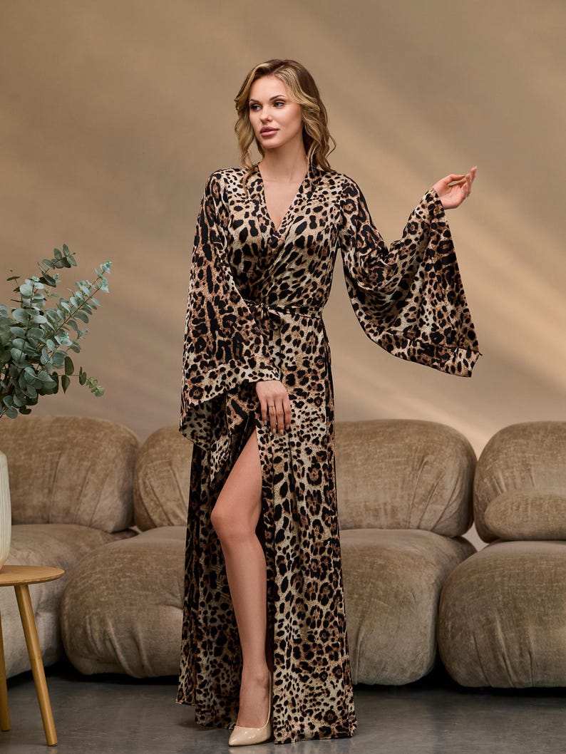 Puede incluir: Una bata larga de estampado de leopardo marr&oacute;n y negro con cuello en V, mangas largas y una abertura lateral. La bata se ata a la cintura con una cinta a juego.