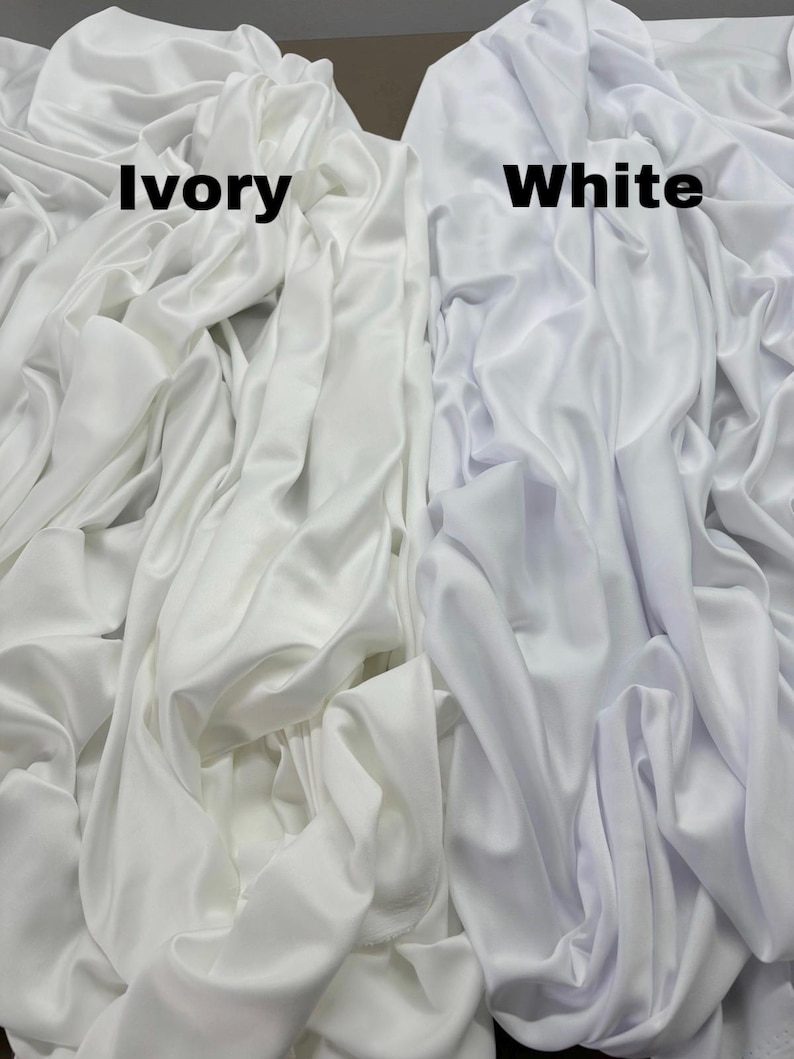 May include: Two fabric swatches, one ivory and one white, are shown side-by-side. The fabric is smooth and has a slight sheen.