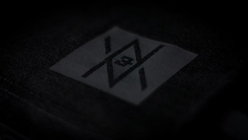 May include: A black patch with a stylized logo featuring a geometric design with intersecting lines and a central letter "Z".