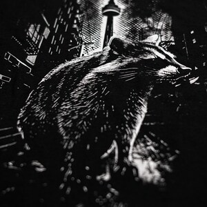 May include: Black and white graphic print of a raccoon walking in front of the CN Tower in Toronto, Canada.