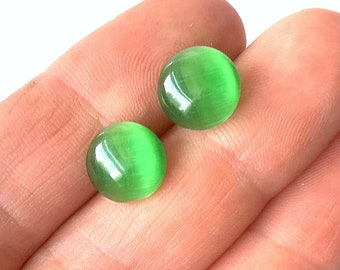 Op de afbeelding: Een paar groene kattenoog-cabochon oorbellen.