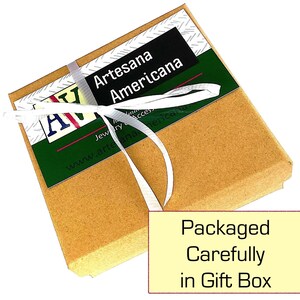 May include: A small, brown gift box tied with a white ribbon. The box has a green and white label with the text "Artesana Americana". The text "Packaged Carefully in Gift Box" is on a yellow rectangle.