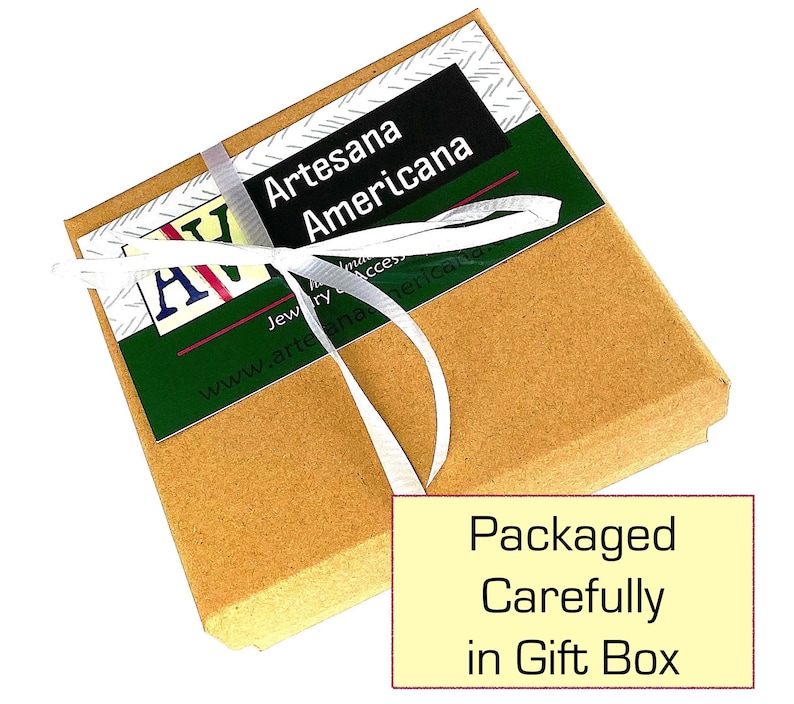 May include: A small, brown gift box tied with a white ribbon. The box has a green and white label with the text "Artesana Americana". The text "Packaged Carefully in Gift Box" is on a yellow rectangle.