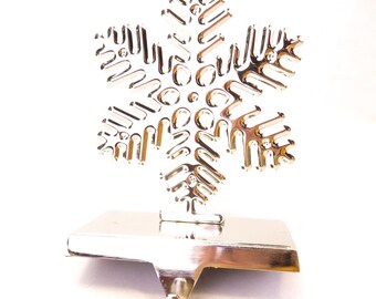 Soporte para calcetín navideño con forma de copo de nieve en color plata vintage, diseño moderno y sencillo.