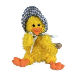 May include: A yellow plush chick toy with fuzzy texture, wearing a blue and white gingham bonnet and a light-colored ribbon tied around its neck. The chick has an orange beak and orange feet, with a small brown paper tag attached to its side.