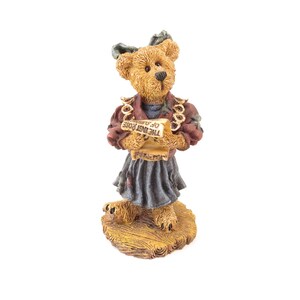 May include: A brown teddy bear figurine wearing a red jacket, blue skirt, and holding a scroll. The scroll reads "THE LAST ROSE OF SUMMER". The bear stands on a wooden base.