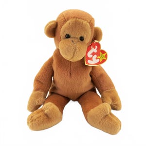 May include: A brown plush monkey toy with a red and yellow tag. The stuffed animal has a soft, fuzzy texture, with a light brown face, ears, hands, and feet. The monkey is sitting with its arms and legs extended.