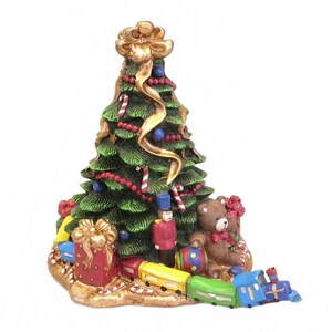 May include: A Christmas tree figurine with a gold bow on top, decorated with red beads, blue ornaments, and candy canes. A toy train, teddy bear, and wrapped gifts surround the tree, creating a festive holiday scene.