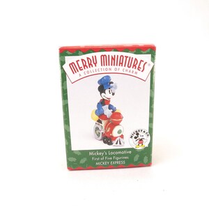 May include: A boxed "Merry Miniatures" collectible featuring Mickey Mouse riding a red locomotive. The figurine is wearing a blue conductor's hat and jacket. The box has a green and red design with the text "Mickey's Locomotive" and "MICKEY EXPRESS".