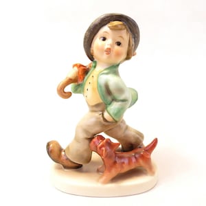 May include: A white ceramic mug with a black handle and the text "But First, Coffee" in a bold, black font. The mug is set against a neutral background, highlighting its simple design.