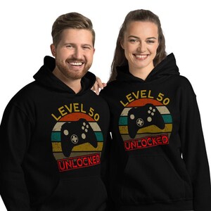 May include: Two black hoodies with a retro-style graphic of a video game controller and the text "Level 50 Unlocked".