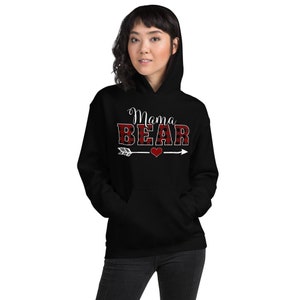 May include: Black hooded sweatshirt with the text "Mama Bear" in white letters with a red and black buffalo plaid pattern. An arrow with a heart is below the text.