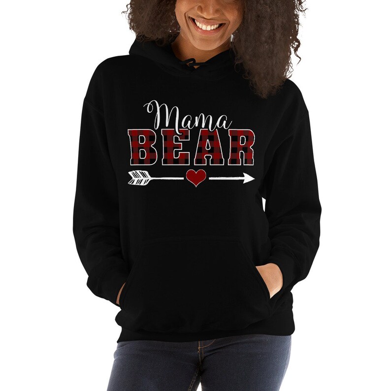 May include: Black hooded sweatshirt with a red and black buffalo plaid design. The text "Mama Bear" is written in white with an arrow and heart graphic.