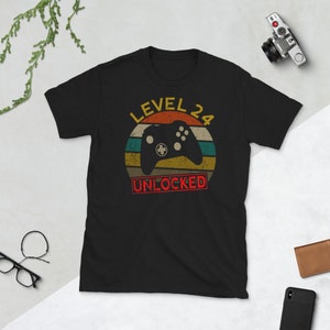 May include: Black t-shirt with a retro-style graphic of a video game controller and the text "LEVEL 24 UNLOCKED".