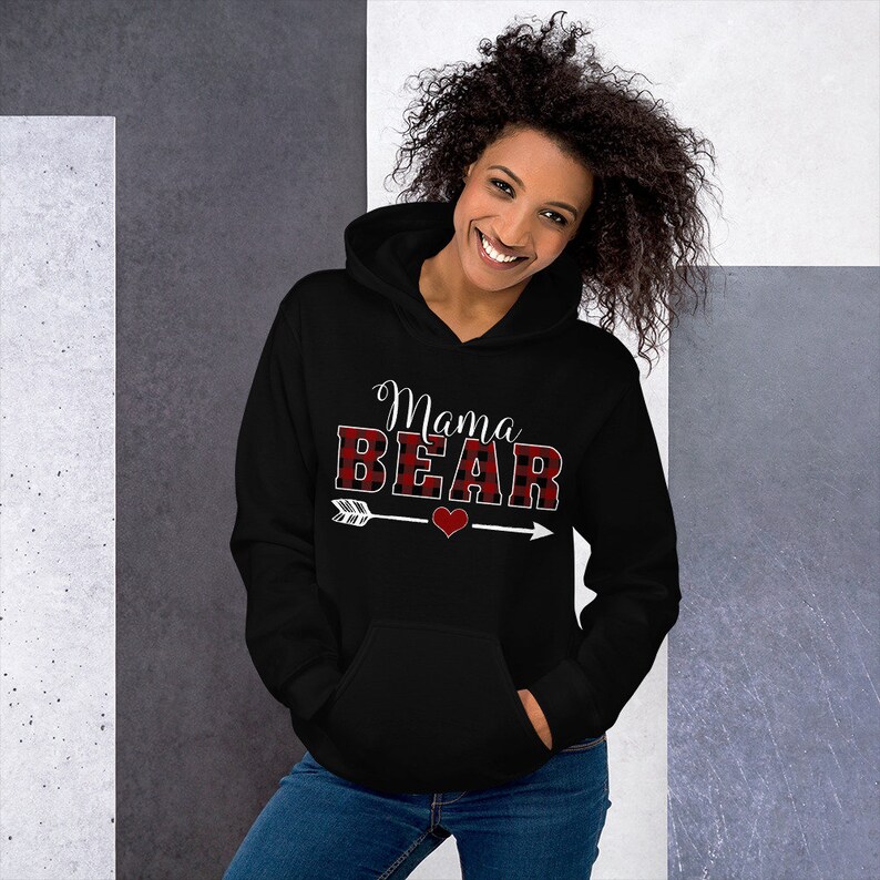 May include: Black hooded sweatshirt with the text "Mama BEAR" in white with a red and black buffalo plaid pattern. An arrow with a red heart is below the text.