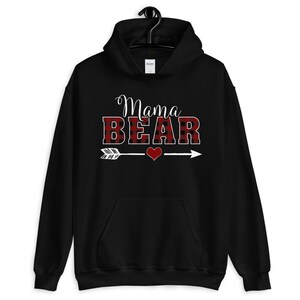 May include: Black hooded sweatshirt with the text "Mama Bear" in white letters with a red and black plaid pattern. An arrow with a red heart is below the text.