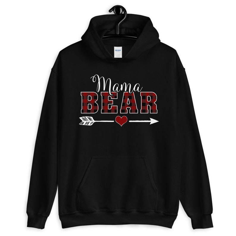 May include: Black hooded sweatshirt with the text "Mama Bear" in white letters with a red and black plaid pattern. An arrow with a red heart is below the text.