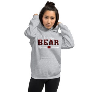 May include: Gray hooded sweatshirt with a red and black buffalo plaid design that says "Mama Bear" in white text with a white arrow and a red heart.