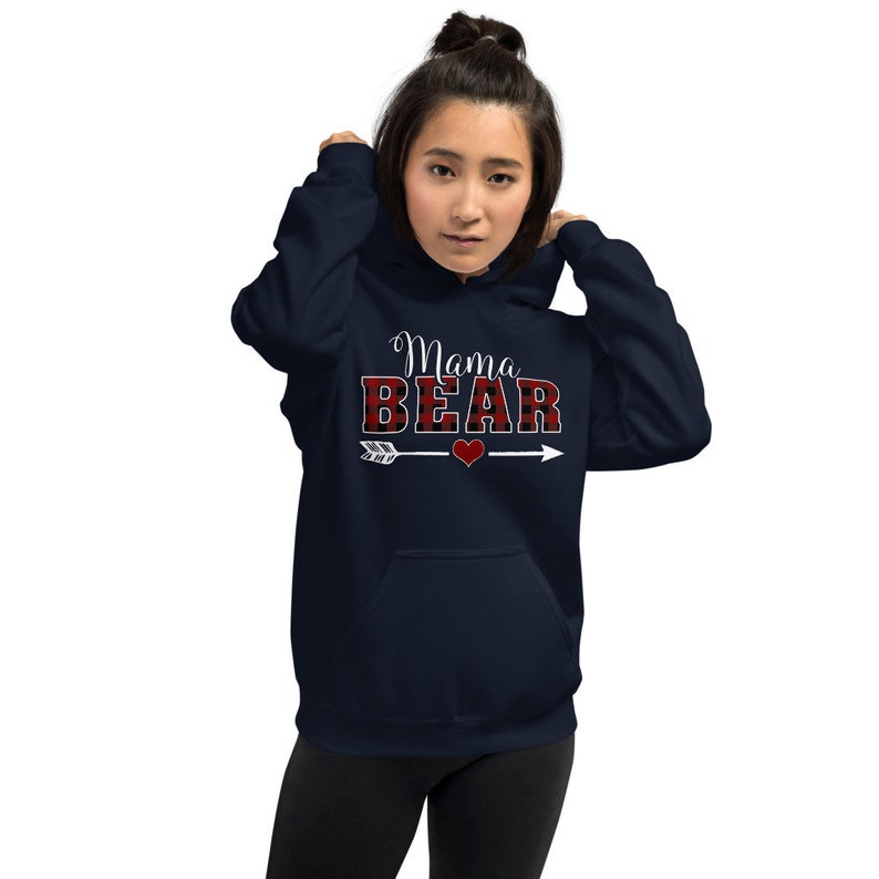 May include: A navy blue hooded sweatshirt with the text "Mama Bear" in white lettering. The word "Bear" is in red and black buffalo plaid.