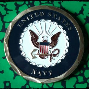 May include: A gold-colored coin with a blue and white seal featuring an eagle, an anchor, and the words "United States Navy".