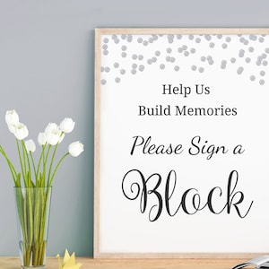 Könnte beinhalten: Ein weißes Schild mit einem silbernen Konfettirand. Auf dem Schild steht "Help Us Build Memories Please Sign a Block".