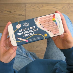 May include: A rectangular tin of Cotton Twist Bright Mix Watercolour Pencils. The tin is blue and white with the words "Bright Mix Watercolour Pencils" in white. The tin contains 10 colored pencils, a paintbrush, and a sharpener.