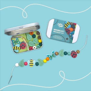 May include: A Minibeast Bracelet Kit with wooden beads and elastic string. The kit includes a variety of colorful beads, including ladybugs, bees, butterflies, and leaf-shaped beads. The kit comes in a small metal tin with the words "Cotton Twist" and "Minibeast Bracelet Kit".