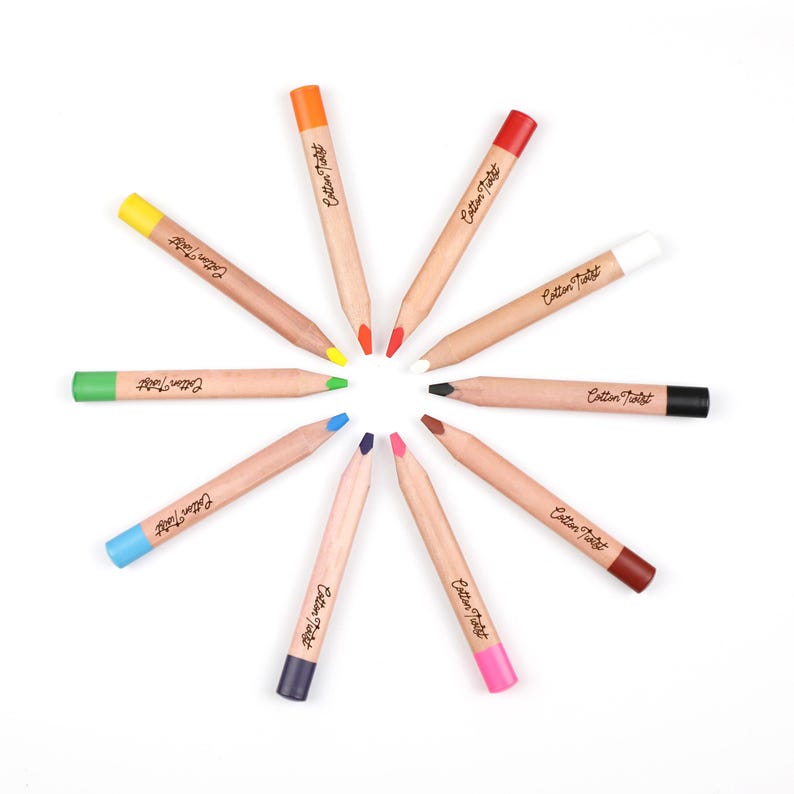 May include: A collection of ten colored pencils arranged in a circular pattern. Each pencil has a natural wood barrel and a colored tip and end. The text "Cotton Twist" is printed on each pencil.