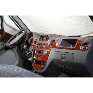 May include: A brown woodgrain dashboard trim kit for a Mercedes-Benz Sprinter van. The kit includes trim pieces for the centre console, door panels, and steering wheel.