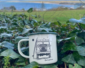 Land Rover front view with surfboard on beach. Cream and green enamel mug – perfect camping mug or gift.