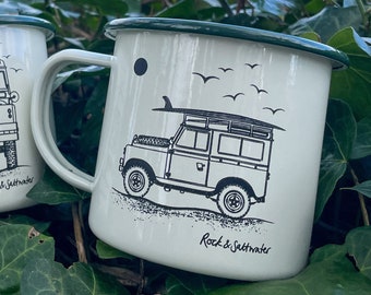 Land Rover side view with surfboard on beach. Cream and green enamel mug – perfect camping mug or gift.