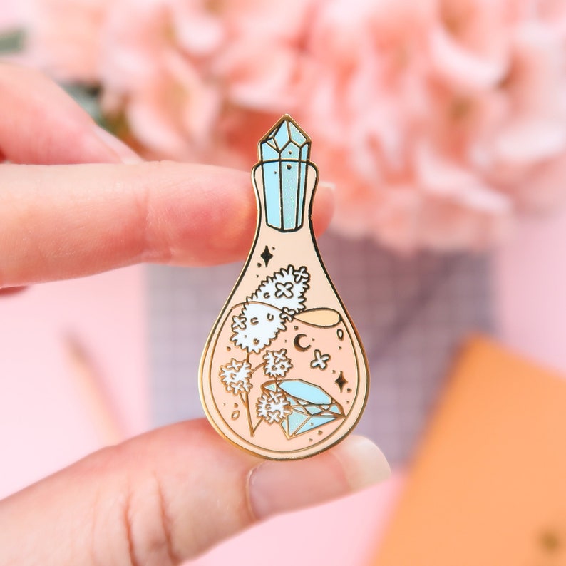 Pastel orange Creativity Potion enamel pin with gold plating