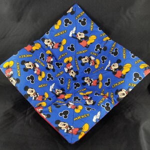 May include: Blue fabric pot holder with a repeating pattern of Mickey Mouse characters and the word "Mickey" in yellow.