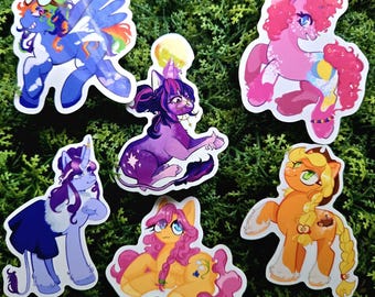 May include: Six colorful cartoon pony stickers with different poses and expressions. The ponies are pink, purple, blue, yellow, and orange. The stickers are perfect for decorating laptops, water bottles, or journals.