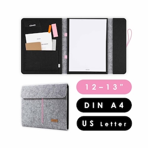 May include: A grey felt folder with a pink zipper pull. The folder is closed and has a small brown leather label with the word "KAVARE" on it. The folder is 12-13 inches in size and fits both A4 and US Letter paper.