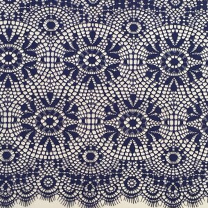 May include: A close-up of navy blue lace trim with a delicate, intricate pattern. The lace is shown next to a ruler measuring 10 centimeters.