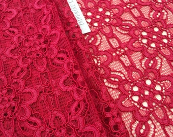 May include: Red lace fabric with a delicate floral pattern. The fabric is folded in half and the label "Imperial Lace" is visible.