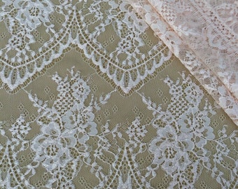 May include: Pale pink lace fabric with a delicate floral pattern. The lace has a scalloped edge and is perfect for crafting and sewing projects.