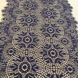 May include: Navy blue lace trim with a delicate floral pattern. The lace has a scalloped edge and is perfect for adding a touch of elegance to any project.